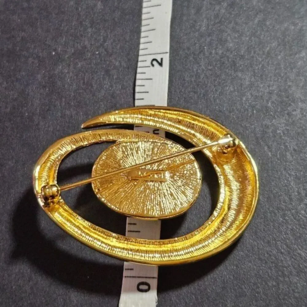 Vintage Monet gold tone swirl brooch